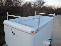 A white enclosed trailer with a roof rack.