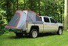 Rightline Gear truck bed tent in thebed of a silver truck in a grassy wooded area.