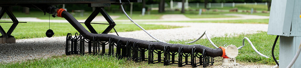 RV sewer hoses connected to dumping station.