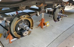 Trailer on jacks with brakes being installed.