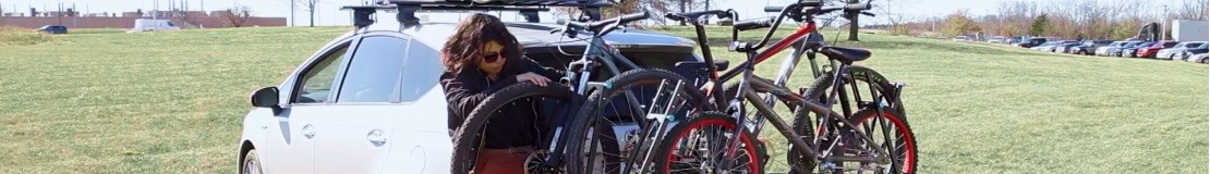 woman loading bike on hitch bike rack. 