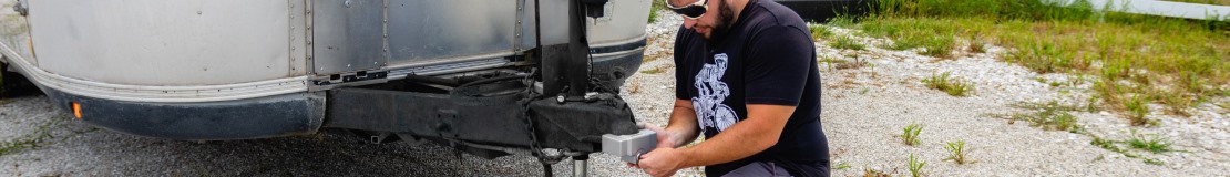 man adding tongue lock to airstream trailer.