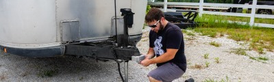 man adding tongue lock to airstream trailer.