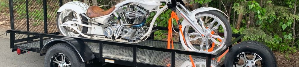 red and white motorcycle tied down on trailer. 