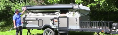 man standing outside pop-up camper. 