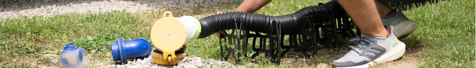 man using sewer hose.