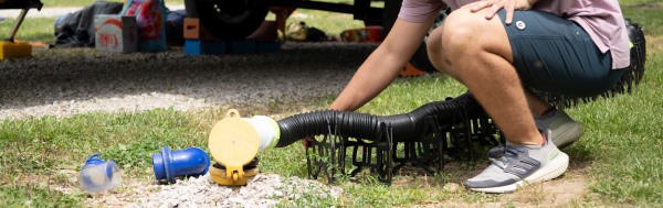 man using sewer hose.