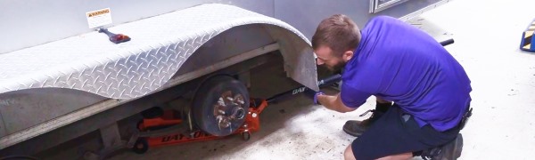 A man changing a tire on an RV.