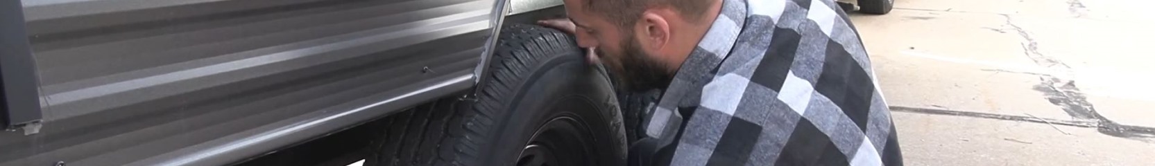 A man changing a tire on an RV.