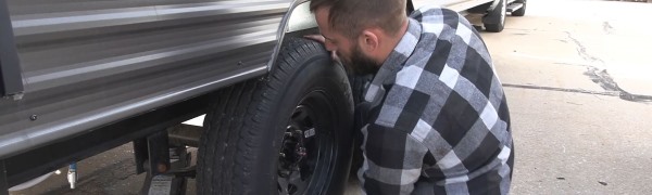 A man changing a tire on an RV.