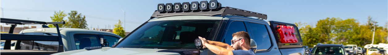 man adjusting lights on truck. 