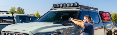 man adjusting lights on truck. 